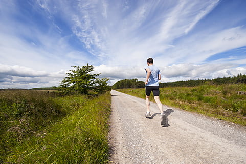 man running on road near grass field, man running nearby green field HD wallpaper