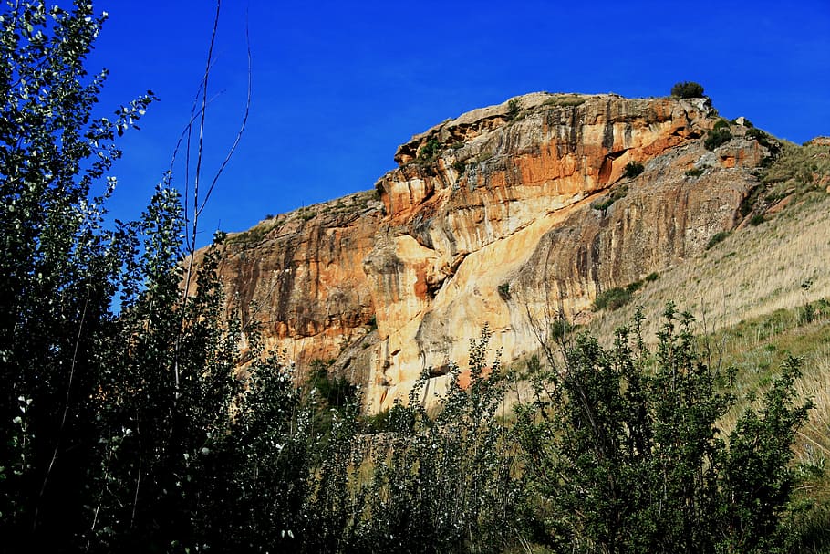 rock, hill, rockface, sheer, orange, earthy, slope, green bush, HD wallpaper