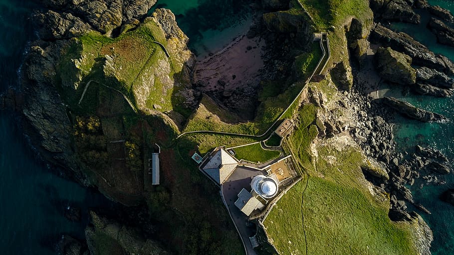 aerial photography of green field, aerial photography of island with building at daytime HD wallpaper