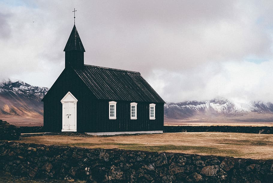 black and white church near open field background of mountain view, green and white chapel in middle of field at distance to snow capped mountains HD wallpaper