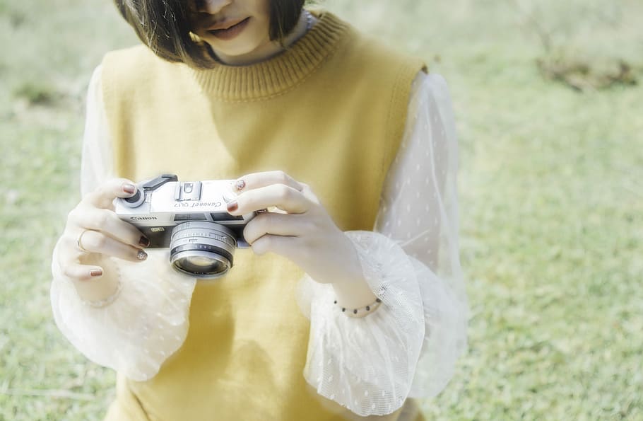 photo of woman holding and looking gray camera, woman looking thru SLR camera HD wallpaper