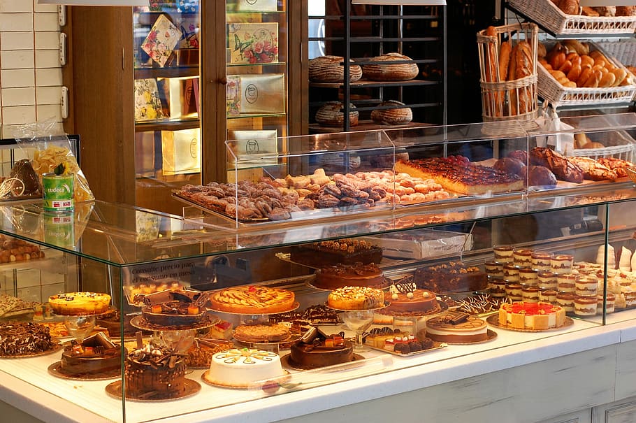 assorted cakes and breads in clear glass food display, marbella