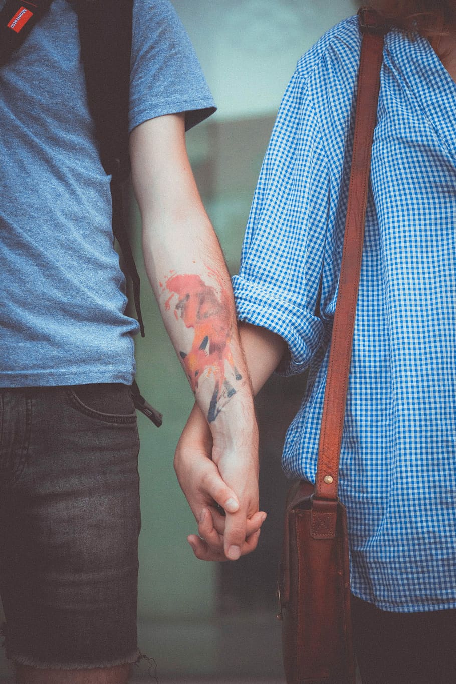 man and woman holding hands, couple holding hands with crossbody bag and backpack HD wallpaper