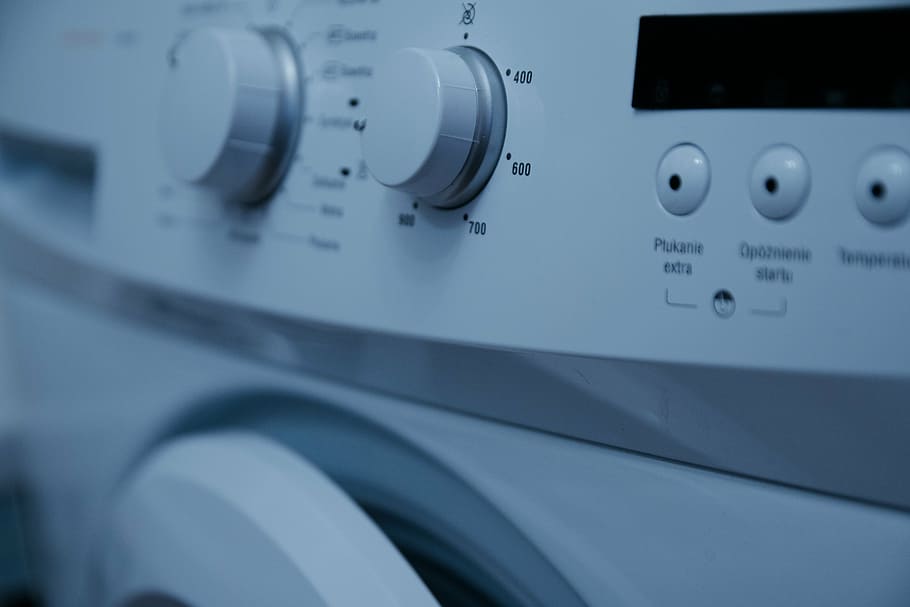 selective focus photography of white front-load clothes washer knob