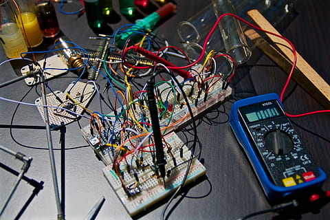electronic circuit boards near tester, close-up photography of blue multimeter and assorted-color electric components HD wallpaper