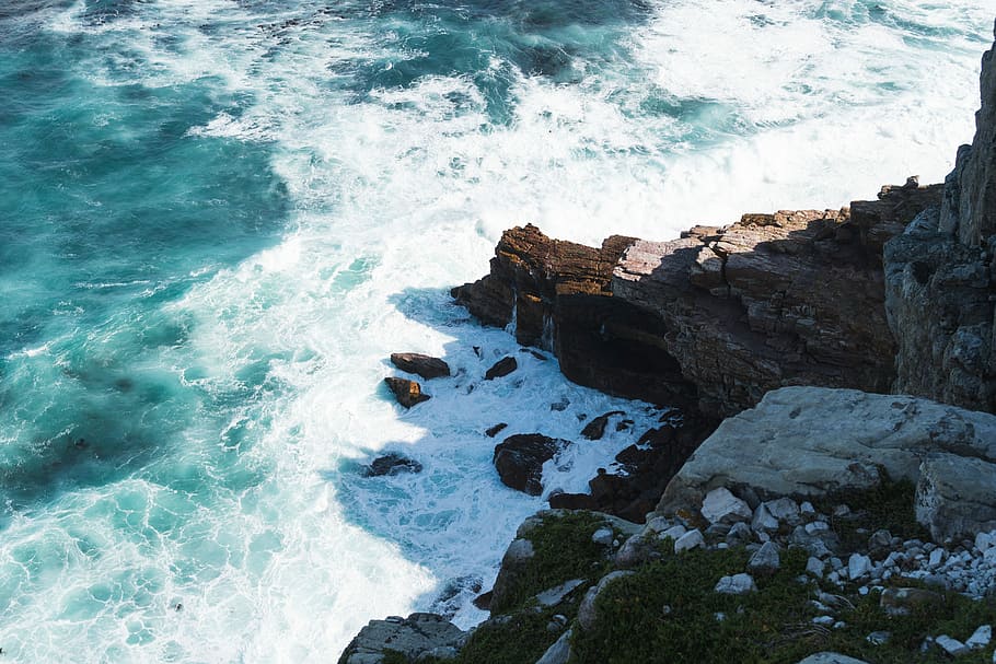 rock formation and body of water, rocky seaside with seawaves during daytime HD wallpaper