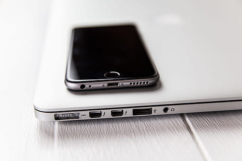 Closeup shot of laptop computer and iPhone mobile smartphone on a white desk HD wallpaper