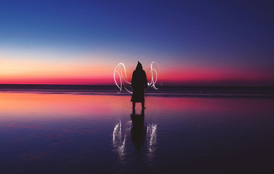 silhouette of person standing on body of water with light wave, person standing on seashore during nighttime HD wallpaper