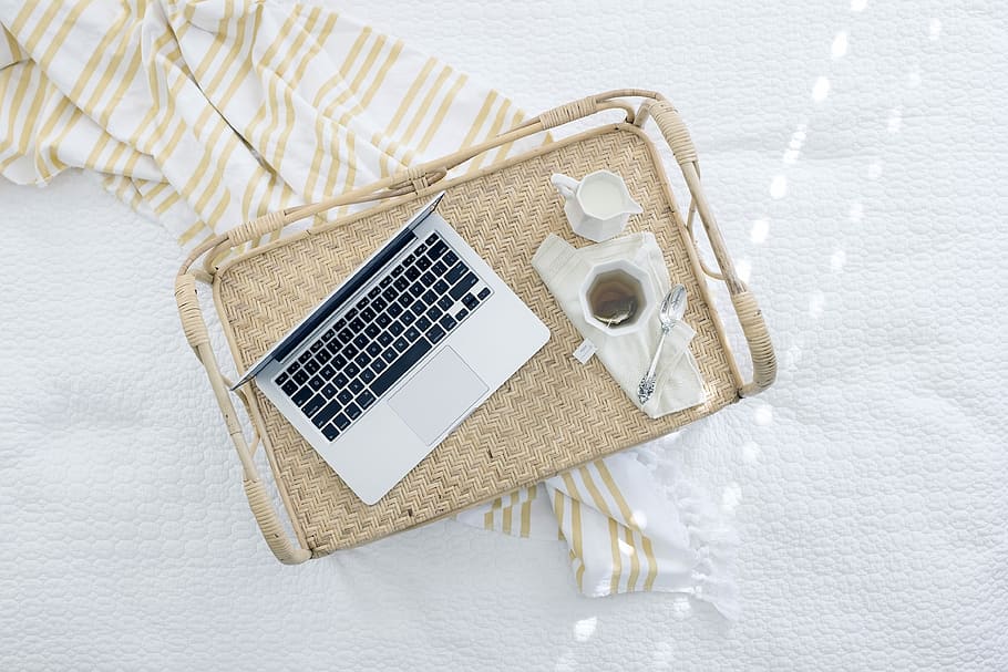 gray laptop computer on beige wicker chair, silver MacBook on top of wooden tray HD wallpaper