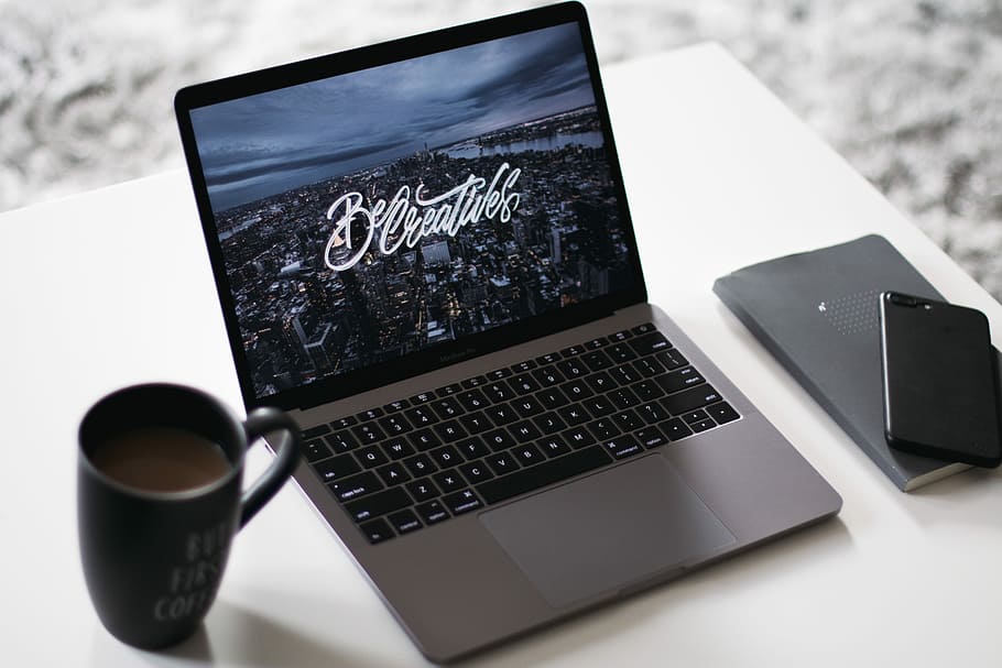 black and gray laptop computer beside black ceramic mug, turned-on MacBook Pro beside black ceramic mug and black iPhone 8 Plus HD wallpaper