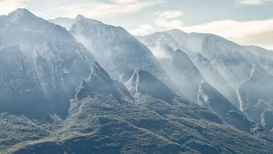 green grass near mountain, gray mountain under gray and white cloudy sky during daytime HD wallpaper