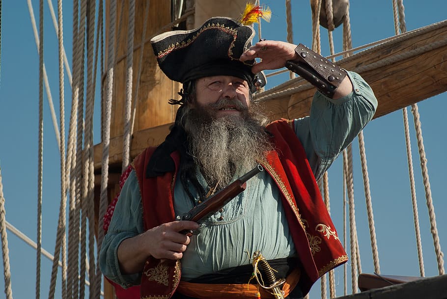 man wearing pirate suit on holding gun, sailboat, marin, corsair