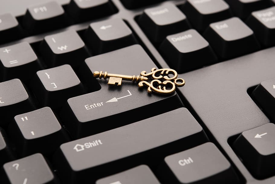 gold-colored skeleton key on computer keyboard, success, plan