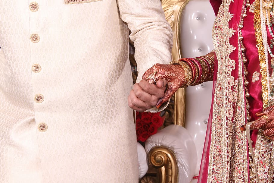 Bride in red and gold dress holds hands with groom in India, man and woman holding hands together, HD wallpaper