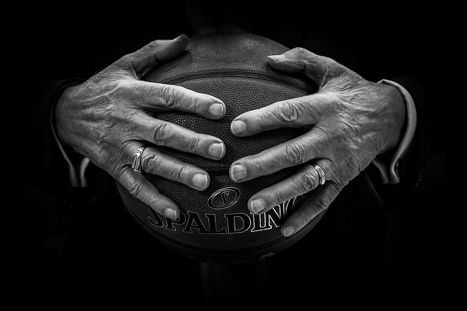 person holding brown Spalding basketball ball, hands, rings, human hand