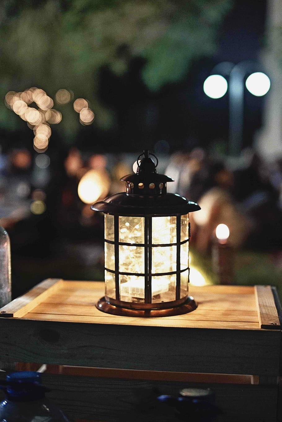 lamp on brown wooden box with shallow depth of field, focus photography of brown lantern on table at night time HD wallpaper