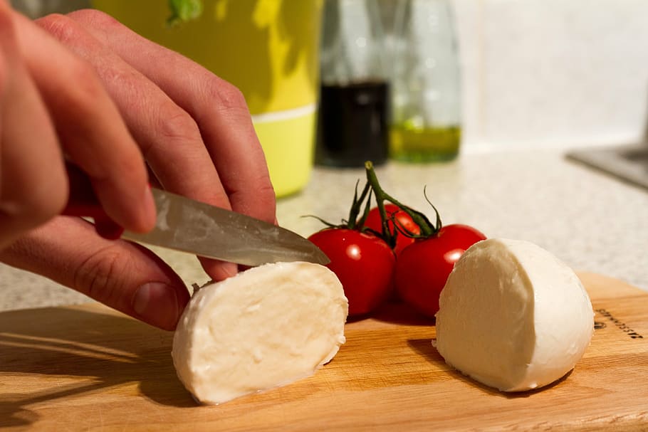 person slicing cheese beside tomatoe, mozzarella, tomatoes, cut, HD wallpaper