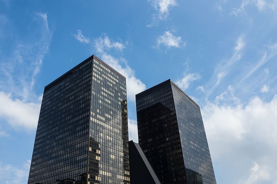 low angle photography of high rise building under white clouds during daytime HD wallpaper