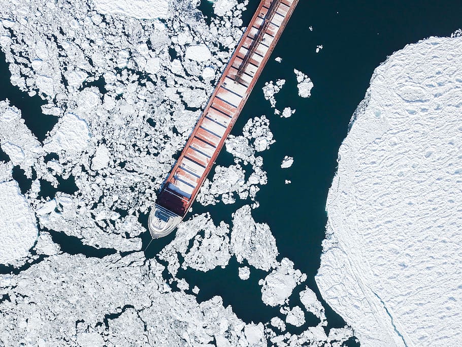 container ship crashing iceberg, aerial photograph of cargo ship between ice
