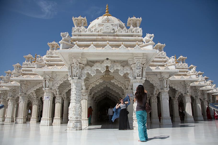 woman taking photo behind white concrete castle at daytime, india