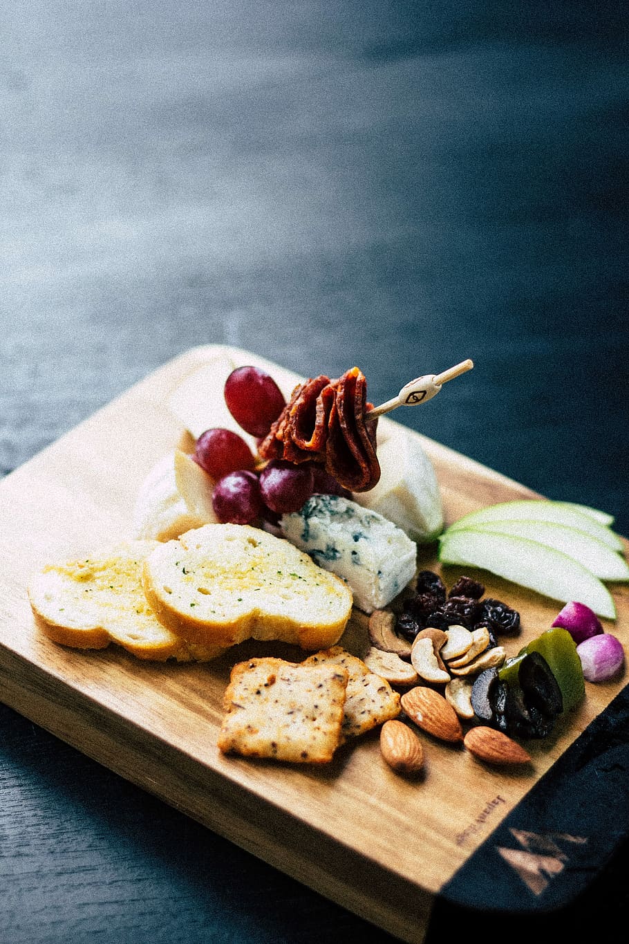assorted seeds and fruits, sliced breads and skewered meat on wooden chopping board HD wallpaper