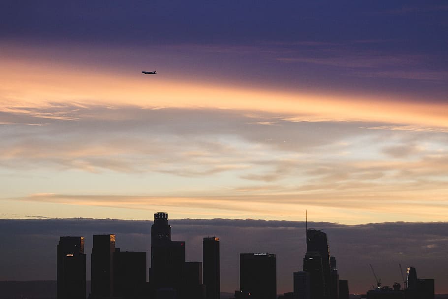 plane flying over silhouette of buildings, silhouette of airplane flying over city buildings HD wallpaper