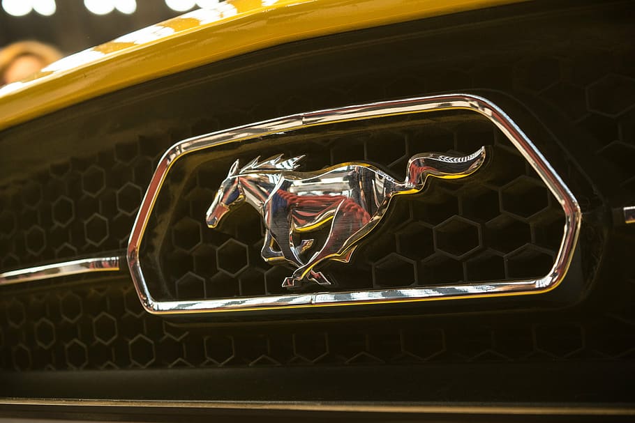 selective focus photography of yellow Ford Mustang emblem, logo