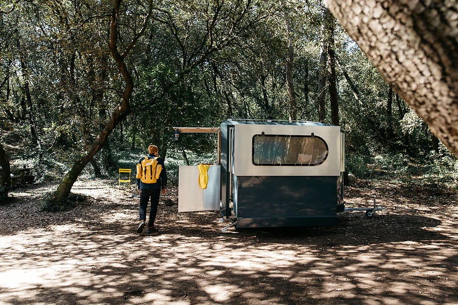 man standing beside enclosed trailer, person beside grey and black trailer HD wallpaper