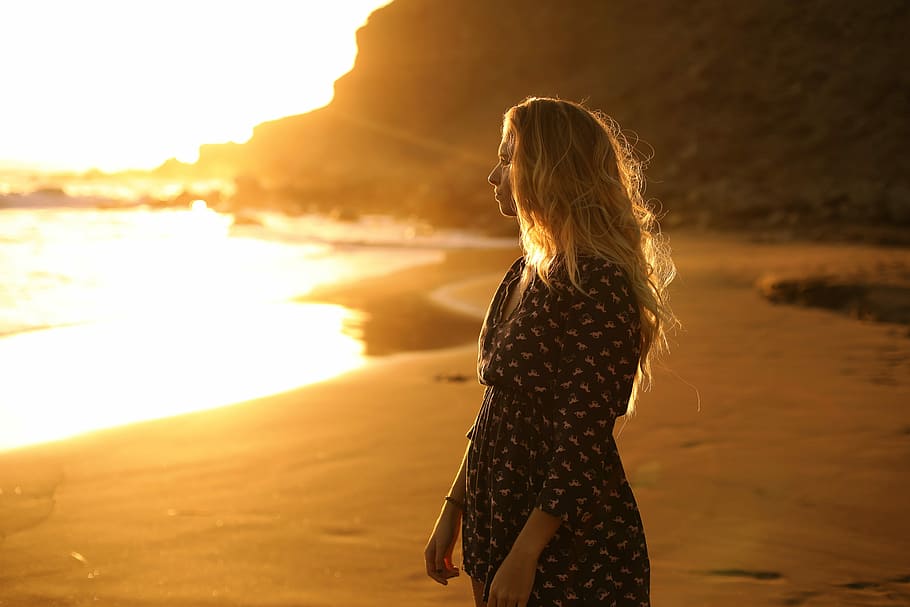 woman standing near body of water, woman standing on shoreline during golden hour HD wallpaper