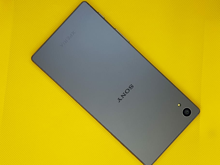 black Sony Xperia, gray Sony Xperia smartphone on yellow surface HD wallpaper