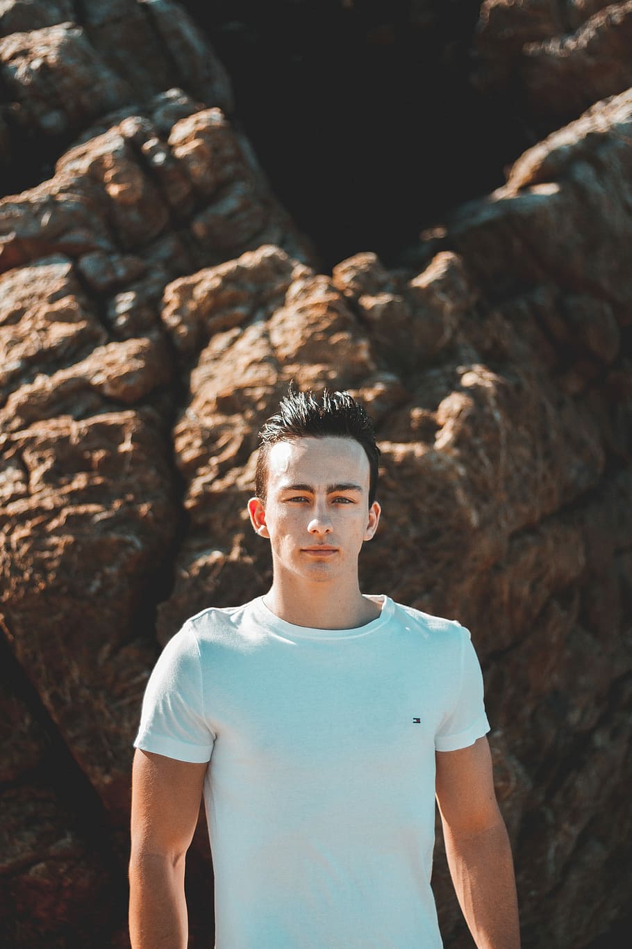 man standing back of stone at daytime, man standing beside boulder HD wallpaper