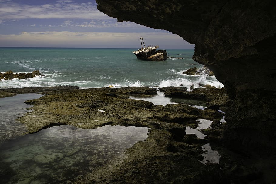 brown and white fishing vessel near rock formation, boat on body of water during daytime HD wallpaper