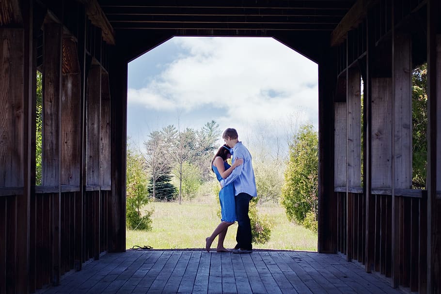 man in blue long-sleeved shirt embracing woman in blue dress HD wallpaper