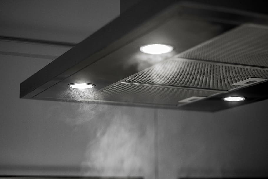 close-up photo of range hood with turn-on lights, extractor, kitchen