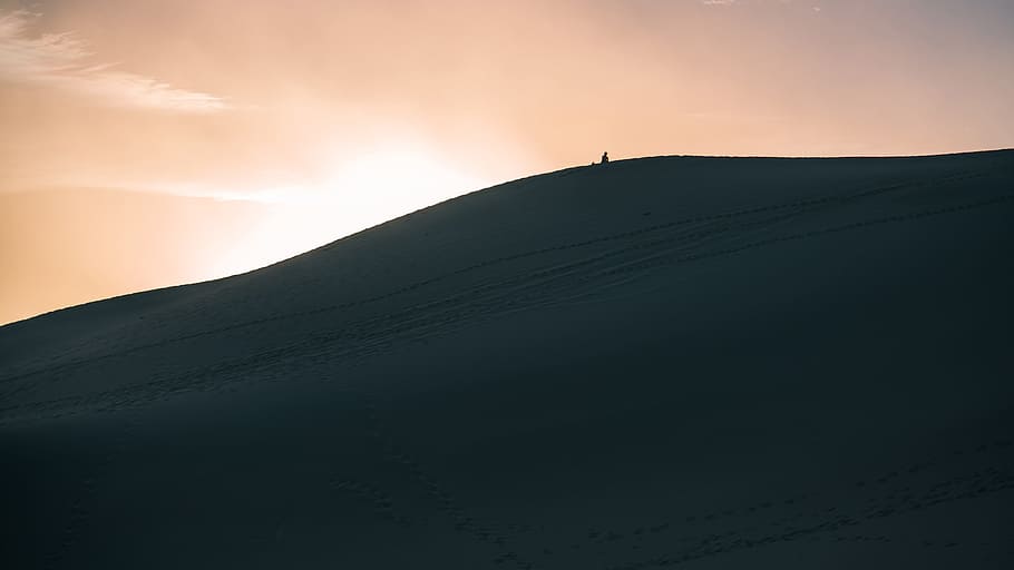 person walking in dune sand, golden hour photography of silhouette of mountain HD wallpaper