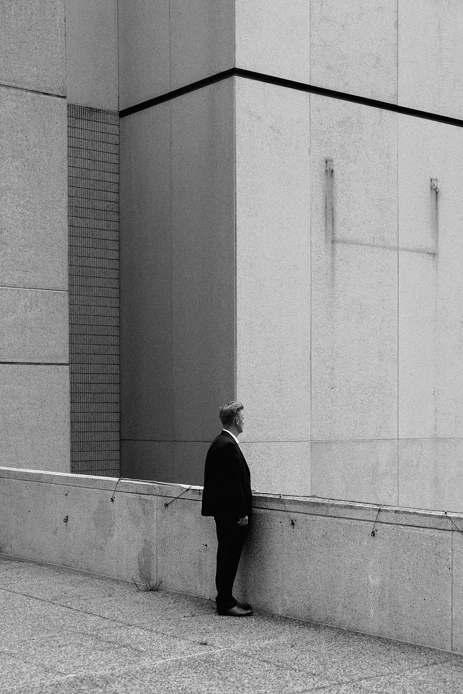 greyscale photo of man standing on bridge during daytime, man standing near concrete wall HD wallpaper