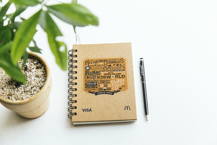 brown book and pen beside green leafed plant, tree, setup, house HD wallpaper