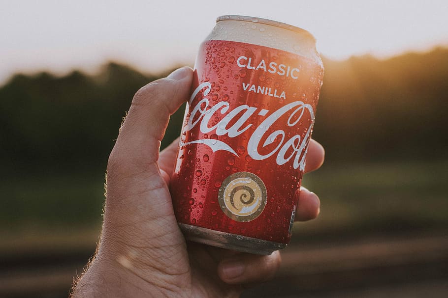 person holding Coca-Cola can, Coca-Cola Classic Vanilla can, coke