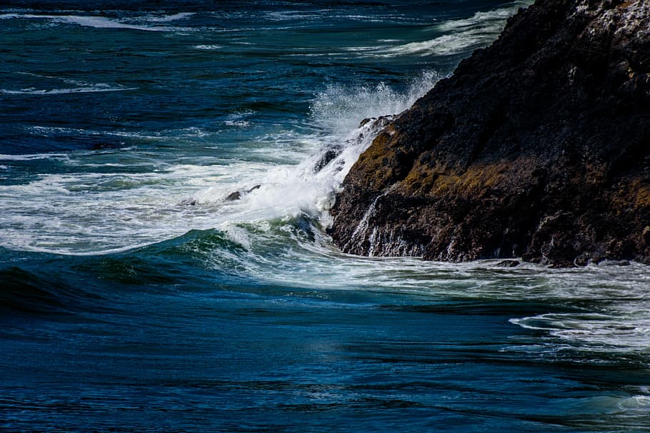 water wave hitting rock formation, mountain beside sea during day HD wallpaper