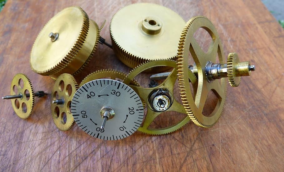 round brass-colored gears and gray analog dial on brown surface HD wallpaper