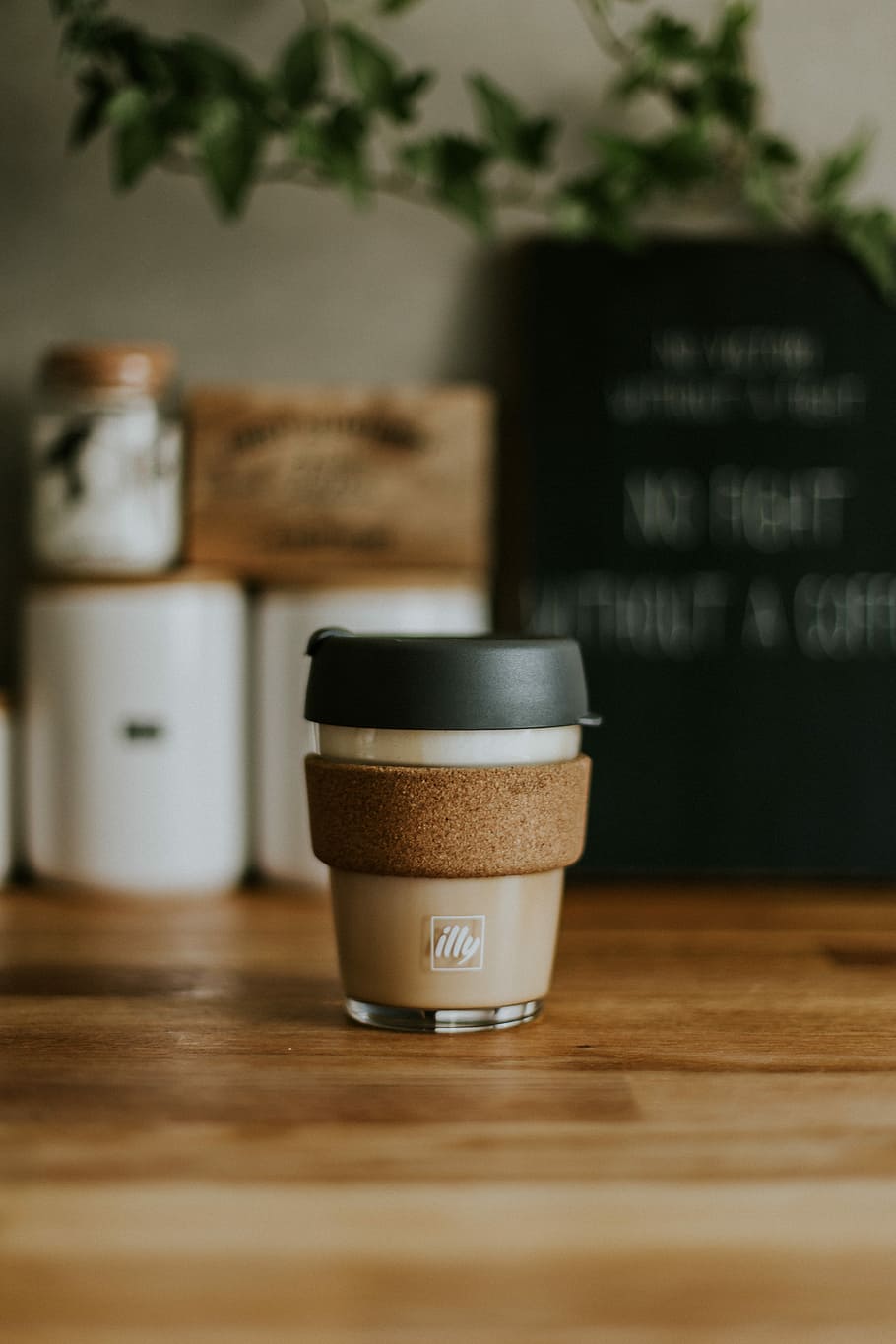 selective focus photography of brown Illy bottle on table, photo of clear and black plastic cup HD wallpaper