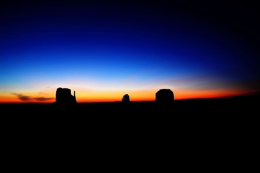 silhouette of rock formation with orange and blue horizon background, silhouette of rocks after sunset