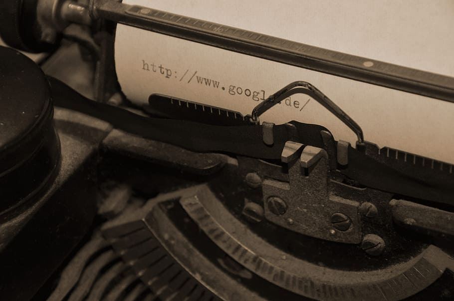 person showing black typing writer with white paper, typewriter