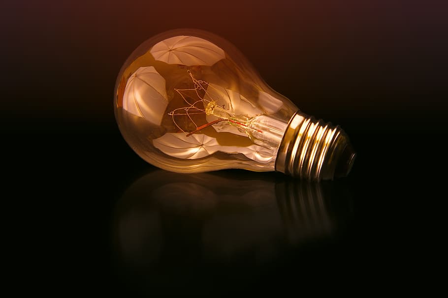 incandescent bulb on black surface, bulb light in black surface