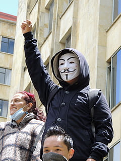 person wearing blue button-up hooded jacket and guy fawkes mask HD wallpaper