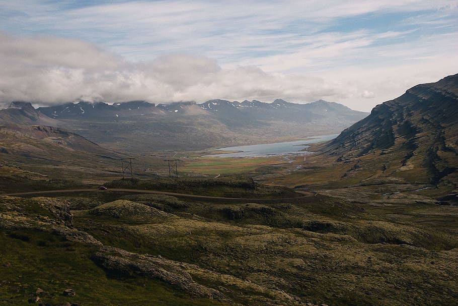 gray mountain near body of water at daytime, person taking photo of green grass mountains HD wallpaper