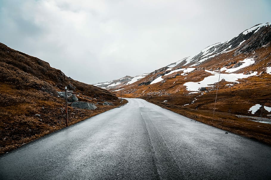 landscape photography of mountain pass, gray concrete pavement HD wallpaper