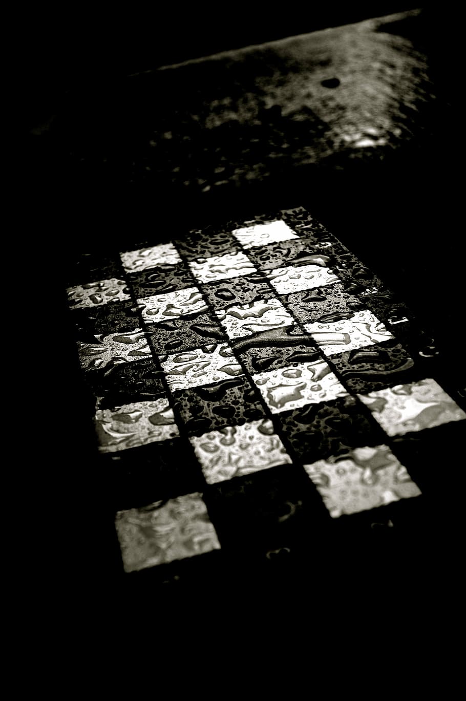 grayscale photo of checked board with water, chess, chess board