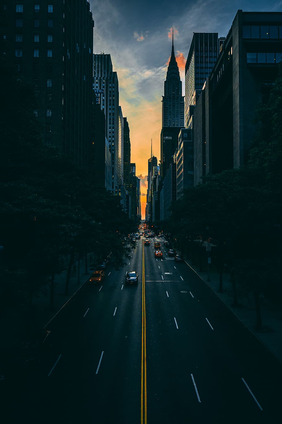 low light photography of vehicle crossing road between high-rise buildings, road photography during nightfall HD wallpaper