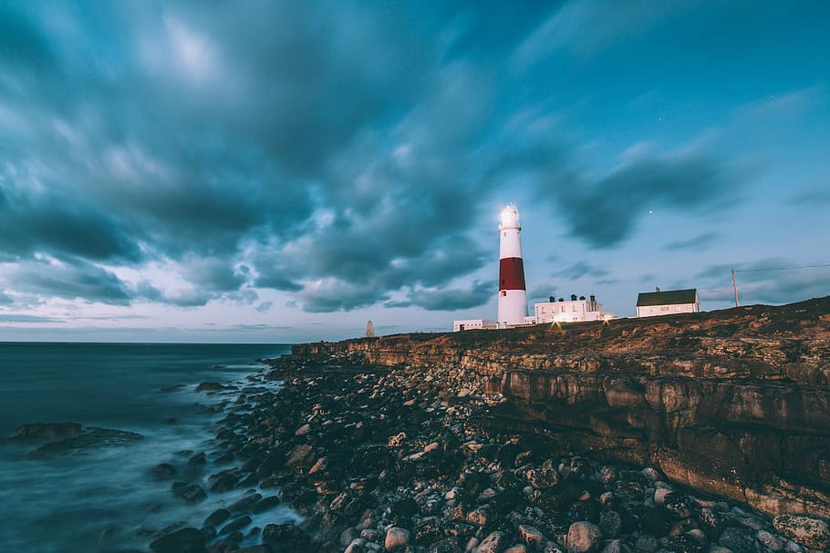 white lighthouse near buildings and cliff photo, ocean, cloud HD wallpaper